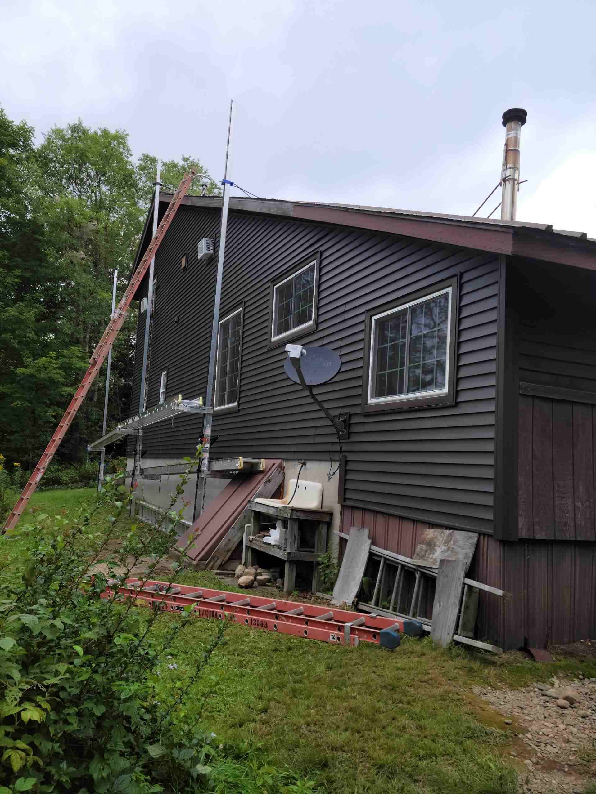 Dark brown house, tools, satellite dish outside.