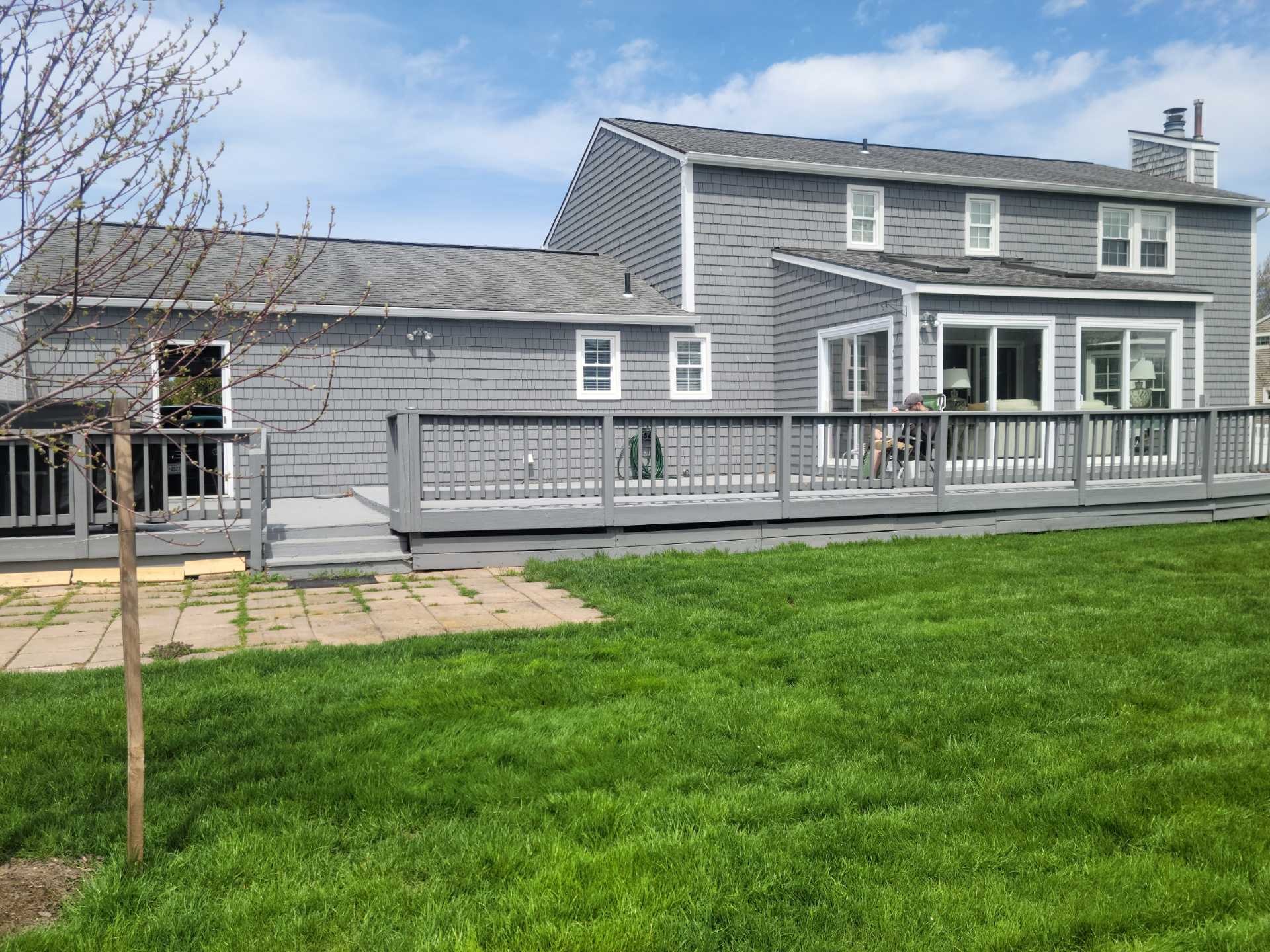 Gray modern house with large backyard deck.