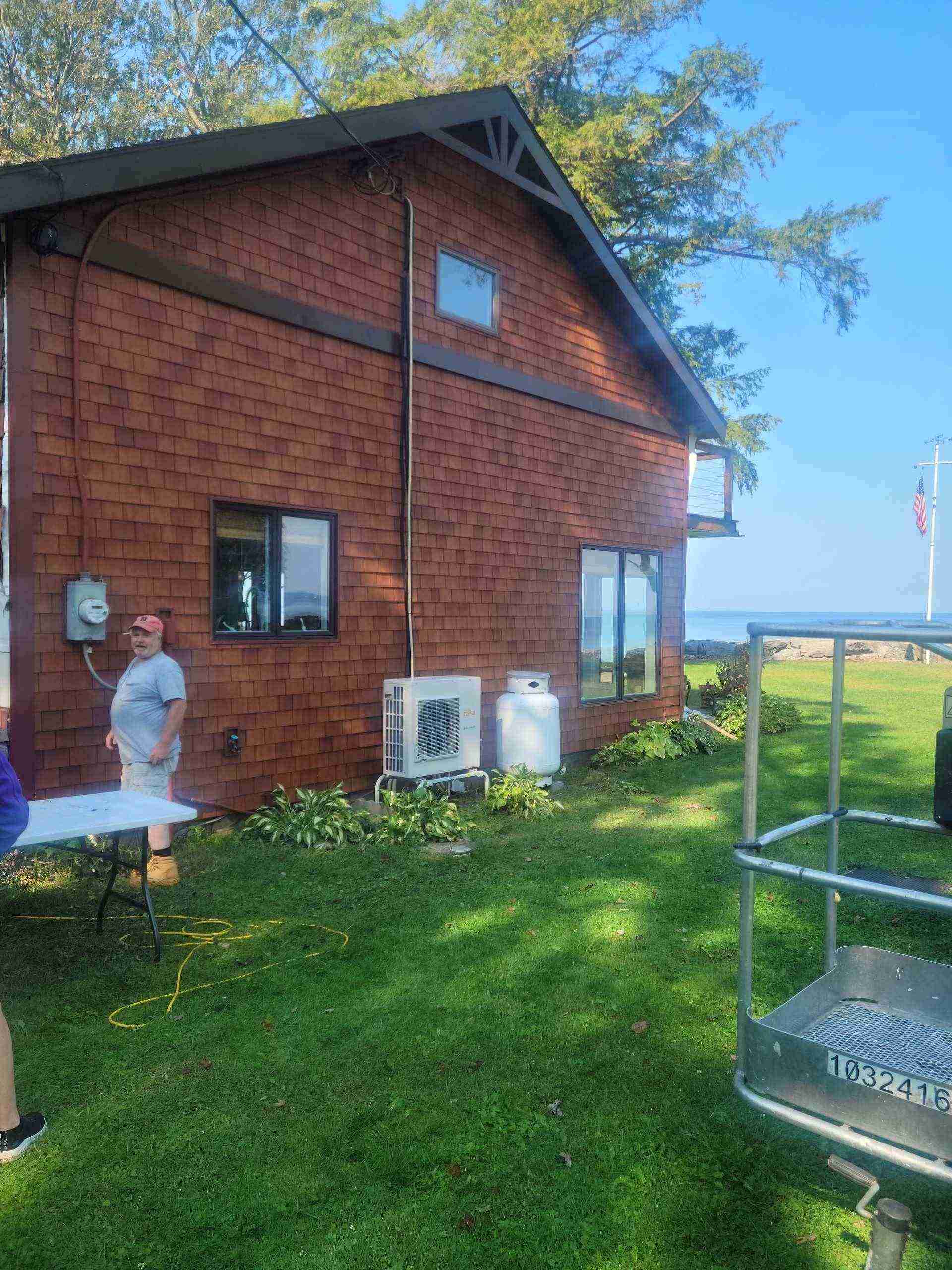 Rustic brown cabin, outdoor unit, man standing.