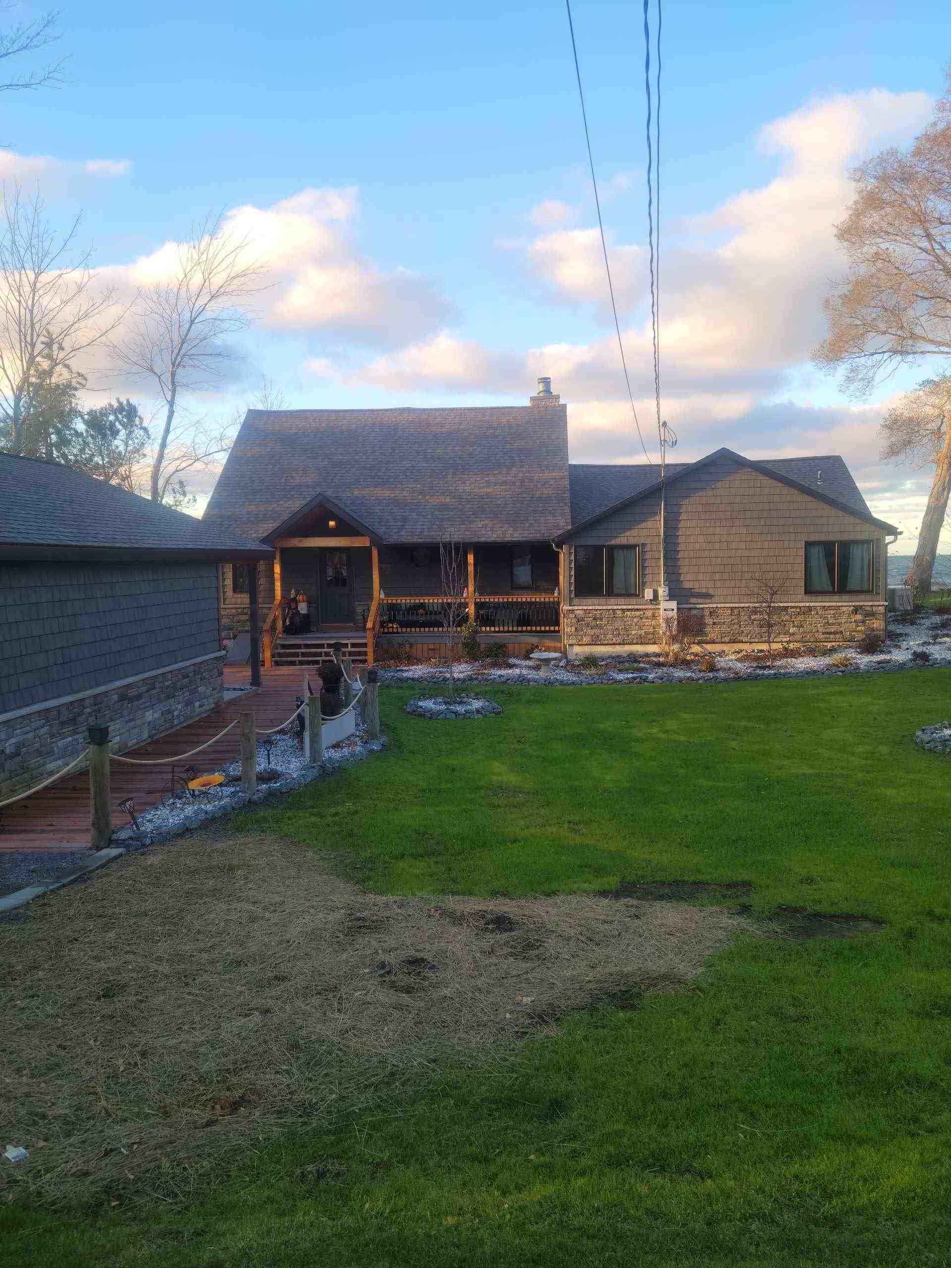 Lodge-style house, wooden porch, cloudy sky.