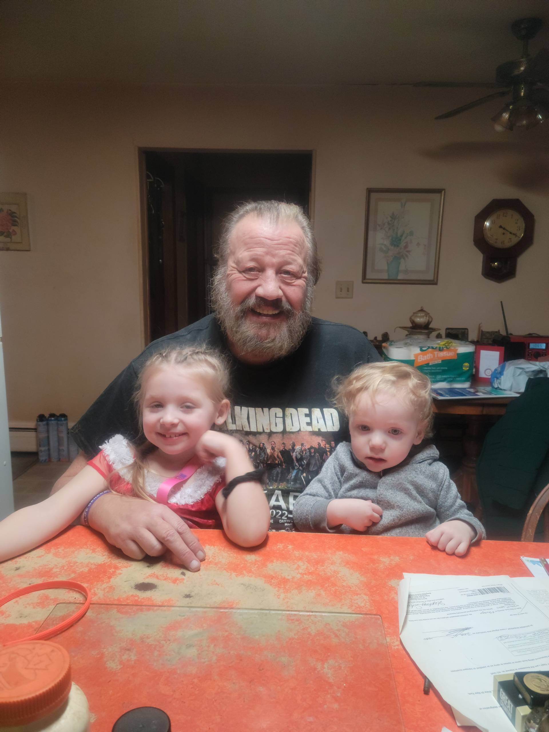 Grandfather smiling, two kids, cozy home.
