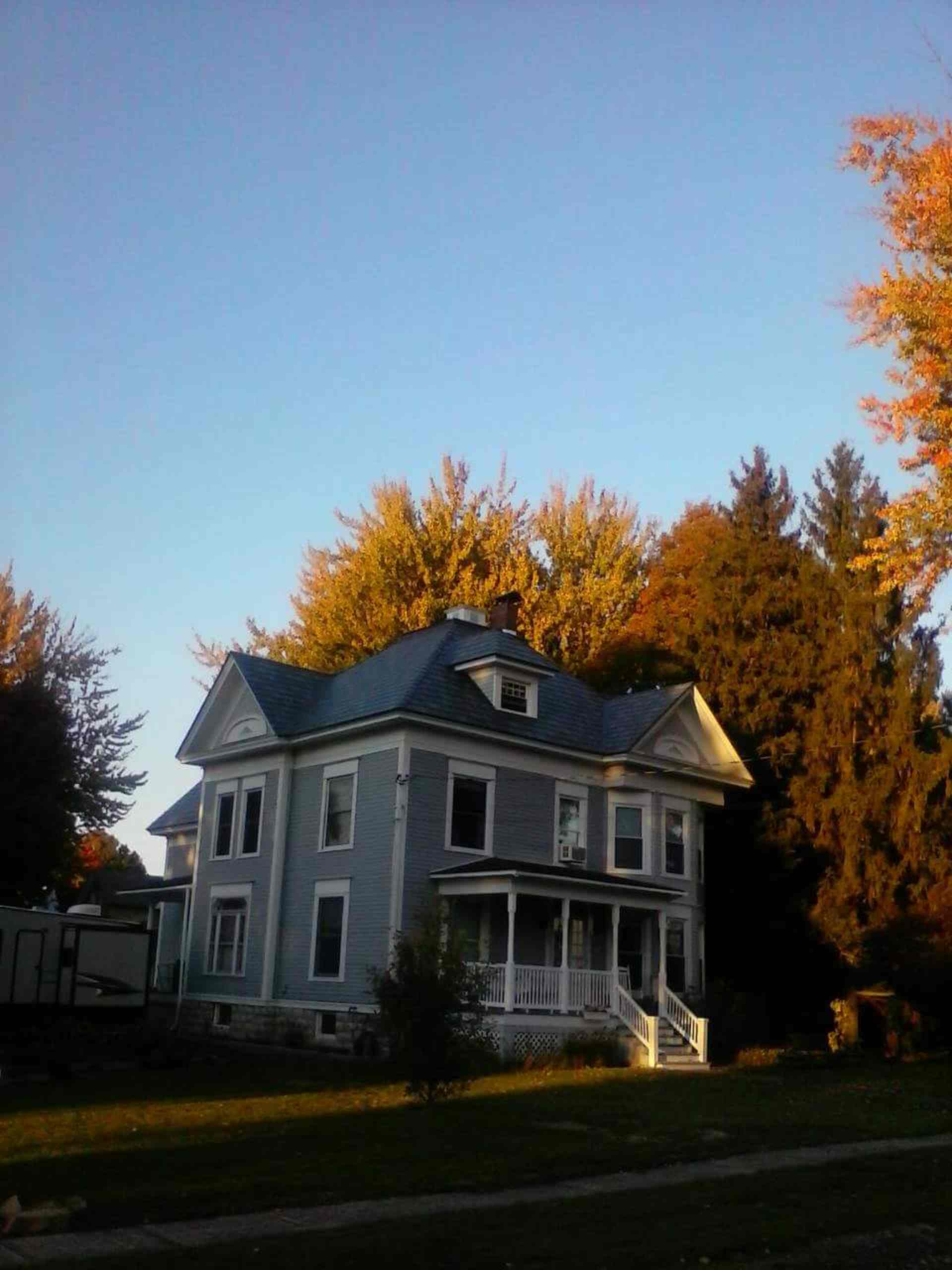 Victorian-style house, autumn trees, warm glow.